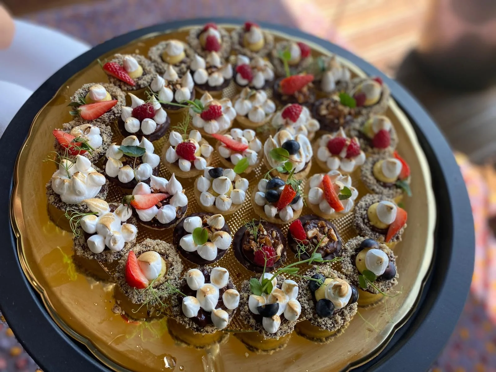 Platte mit Mini-Baiser-Tartelettes und Früchten
